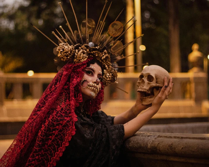 a woman dressed in a skeleton makeup holding a skull