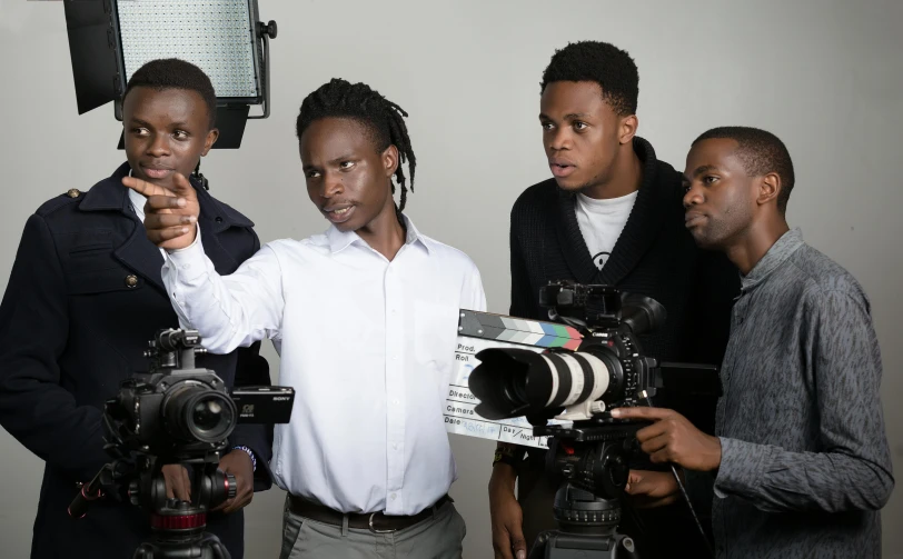 five men are standing around with a camera