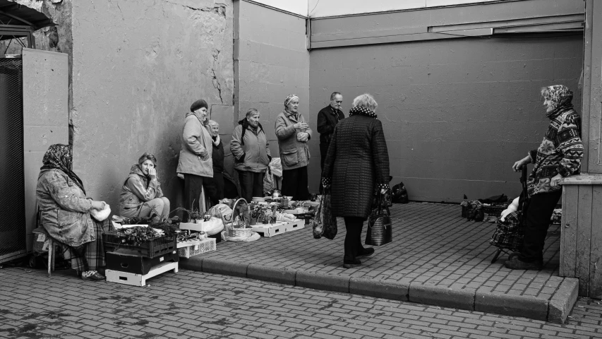 people standing in front of stores on the sidewalk