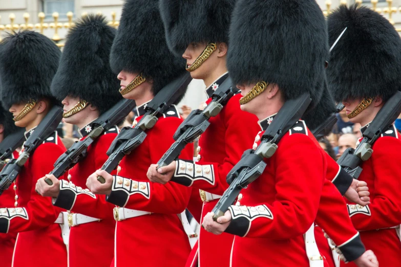 men dressed in red uniform holding rifles