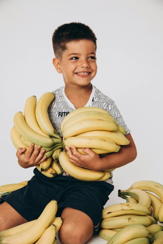 boy with bananas sitting on floor looking at camera