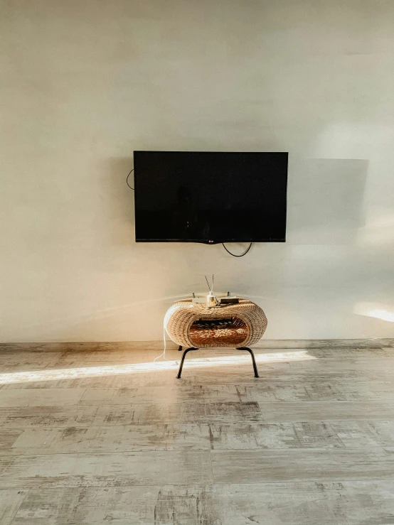 a television is on on the wall with a table in front