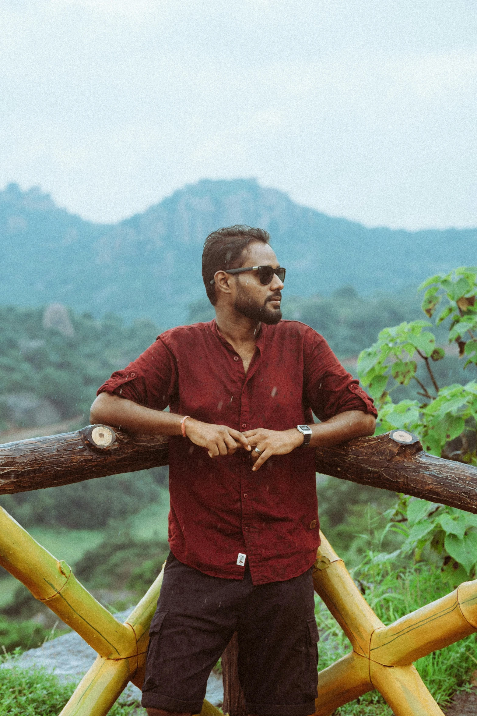 a man standing next to some logs on the side of a road