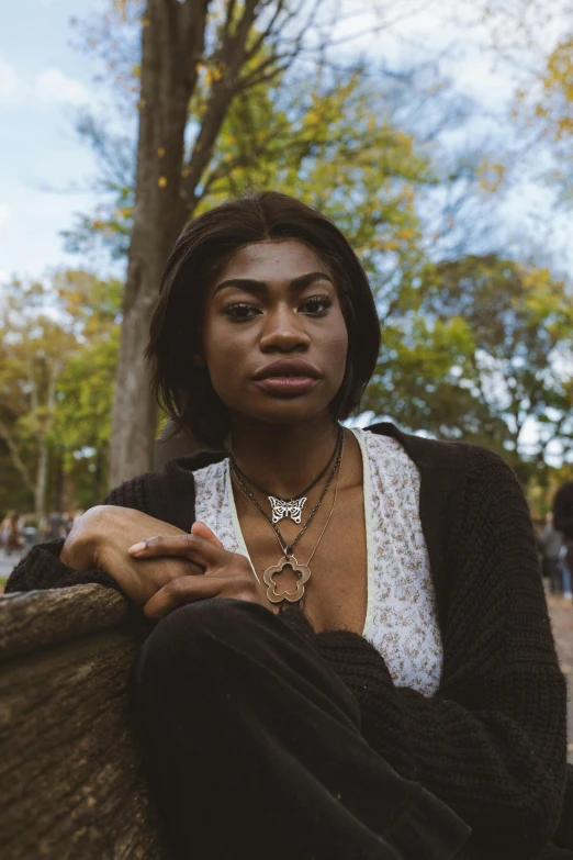 an attractive woman with an afro sitting on the ground