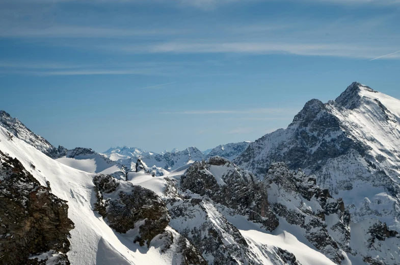 a man in ski gear sitting on top of a snow covered mountain