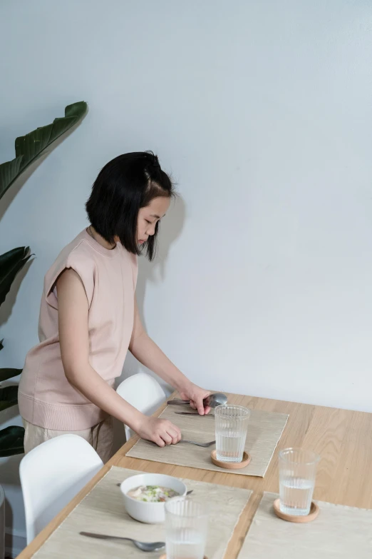 a woman is sitting at a wooden table with food