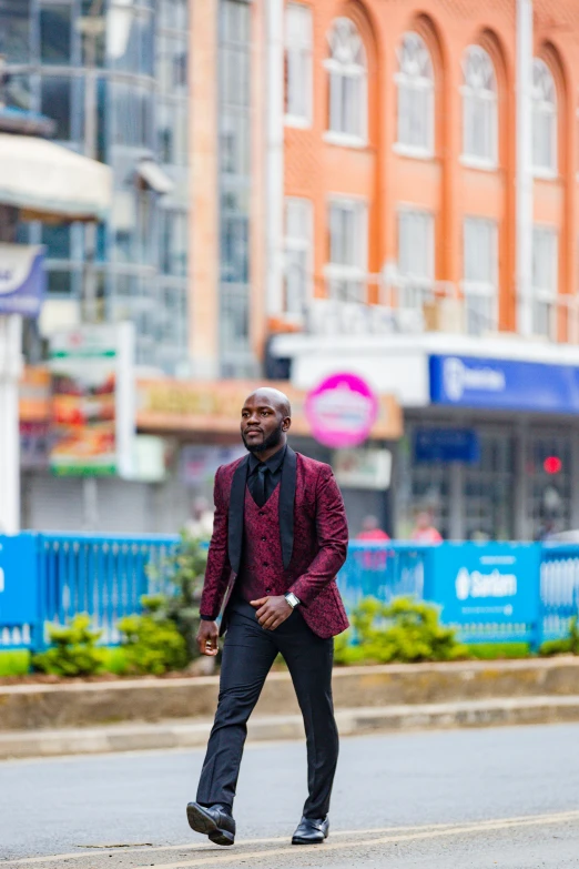 a man walking across a street wearing a purple suit