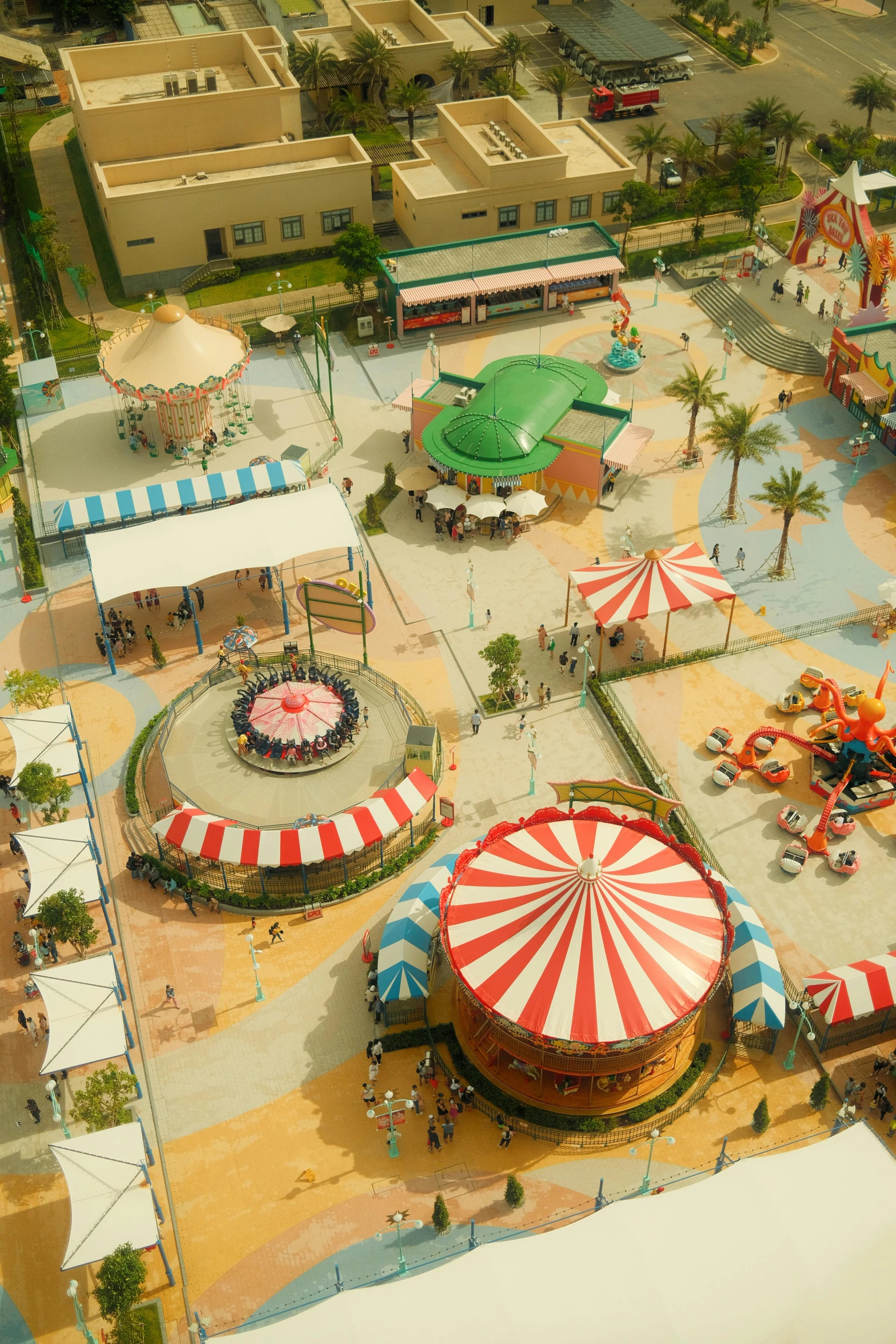 a large carnival park with rides and colorful tents