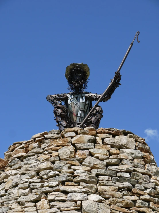 statue sitting on top of stone tower holding a rifle