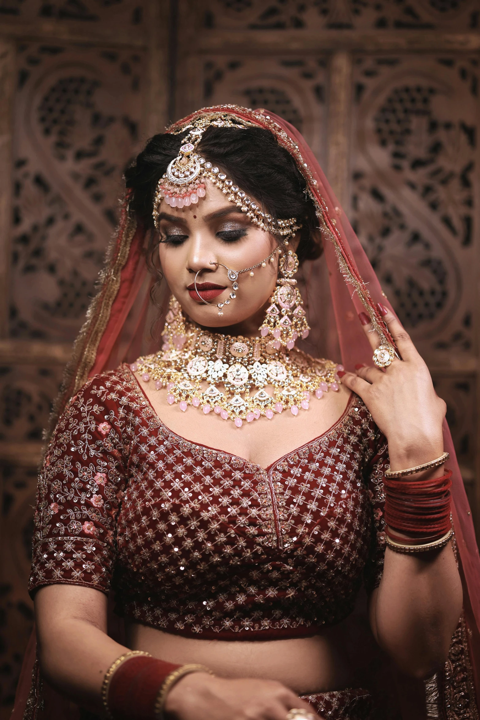 an indian bride dressed in red with jewellery and makeup