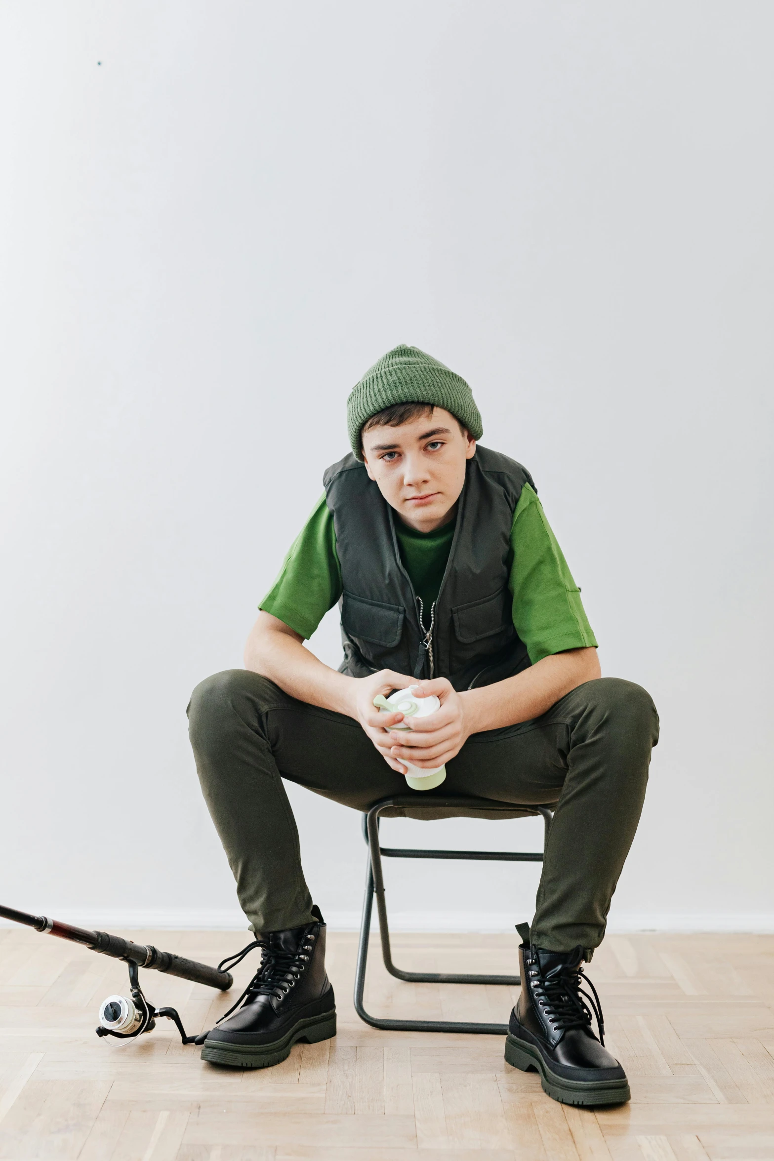 a young man is sitting in a chair while holding a baseball bat