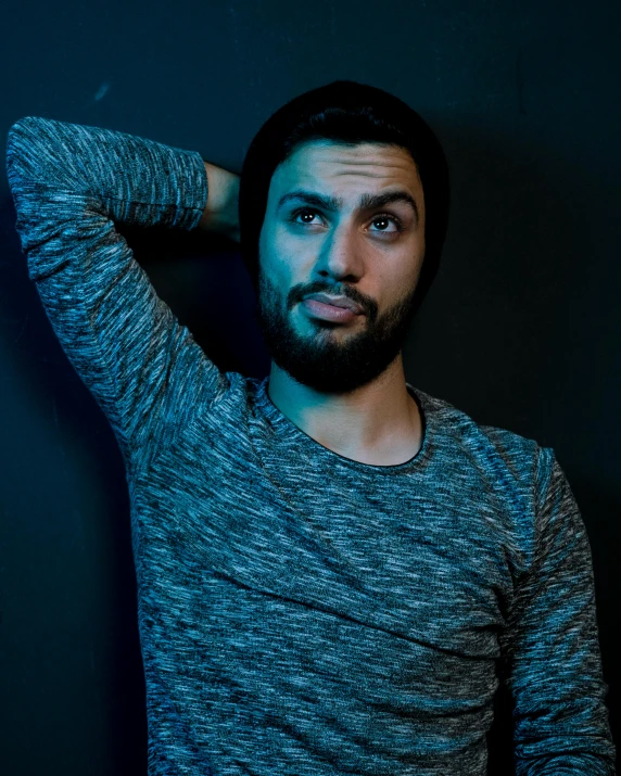 a man with a beard posing in front of a dark background