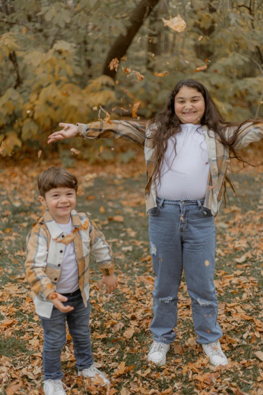 a couple of young s standing in leaves