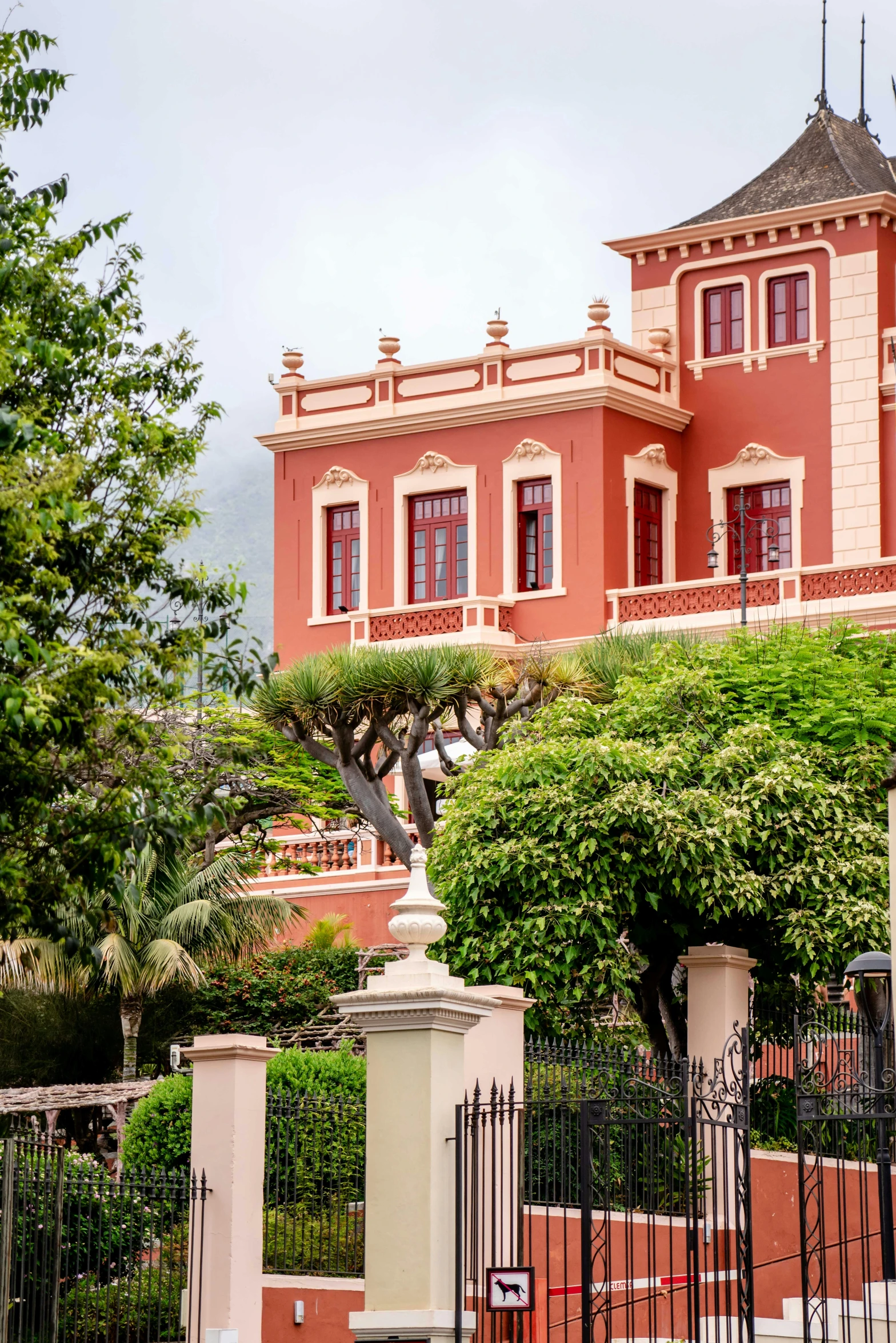 an orange and pink house has tall chimneys on the roof