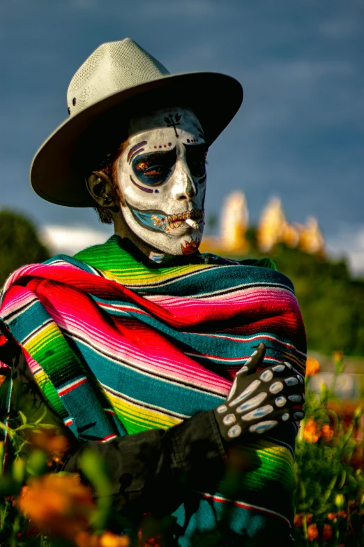 a skeleton wearing a mexican outfit and hat sits in the grass
