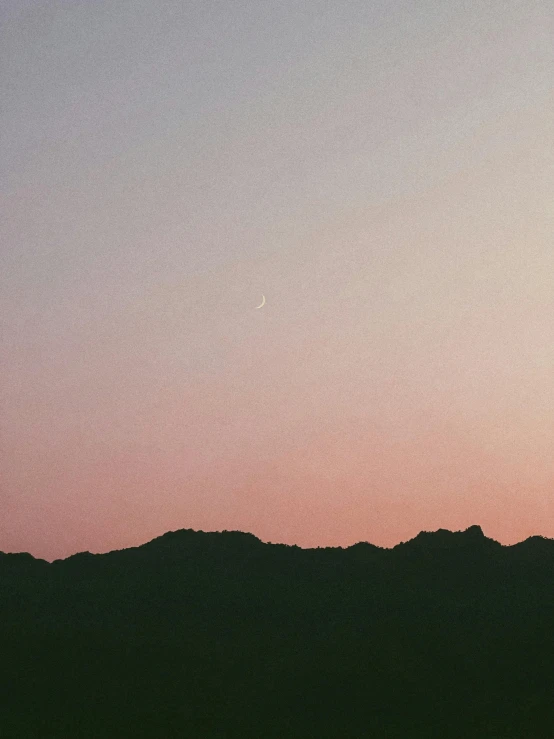 silhouettes of a mountain against an orange sky