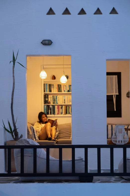 woman sitting on her bed looking out the window