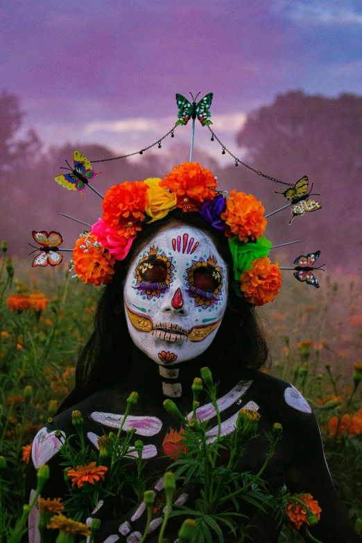 a woman wearing day of the dead makeup and floral headdress