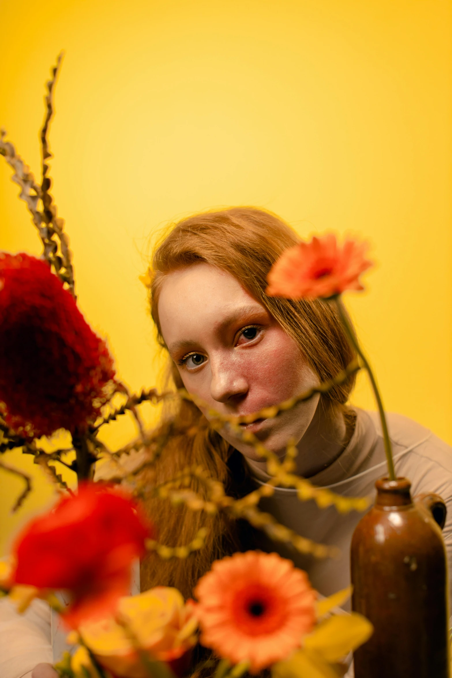 a girl with red lipstick and flowers in a vase