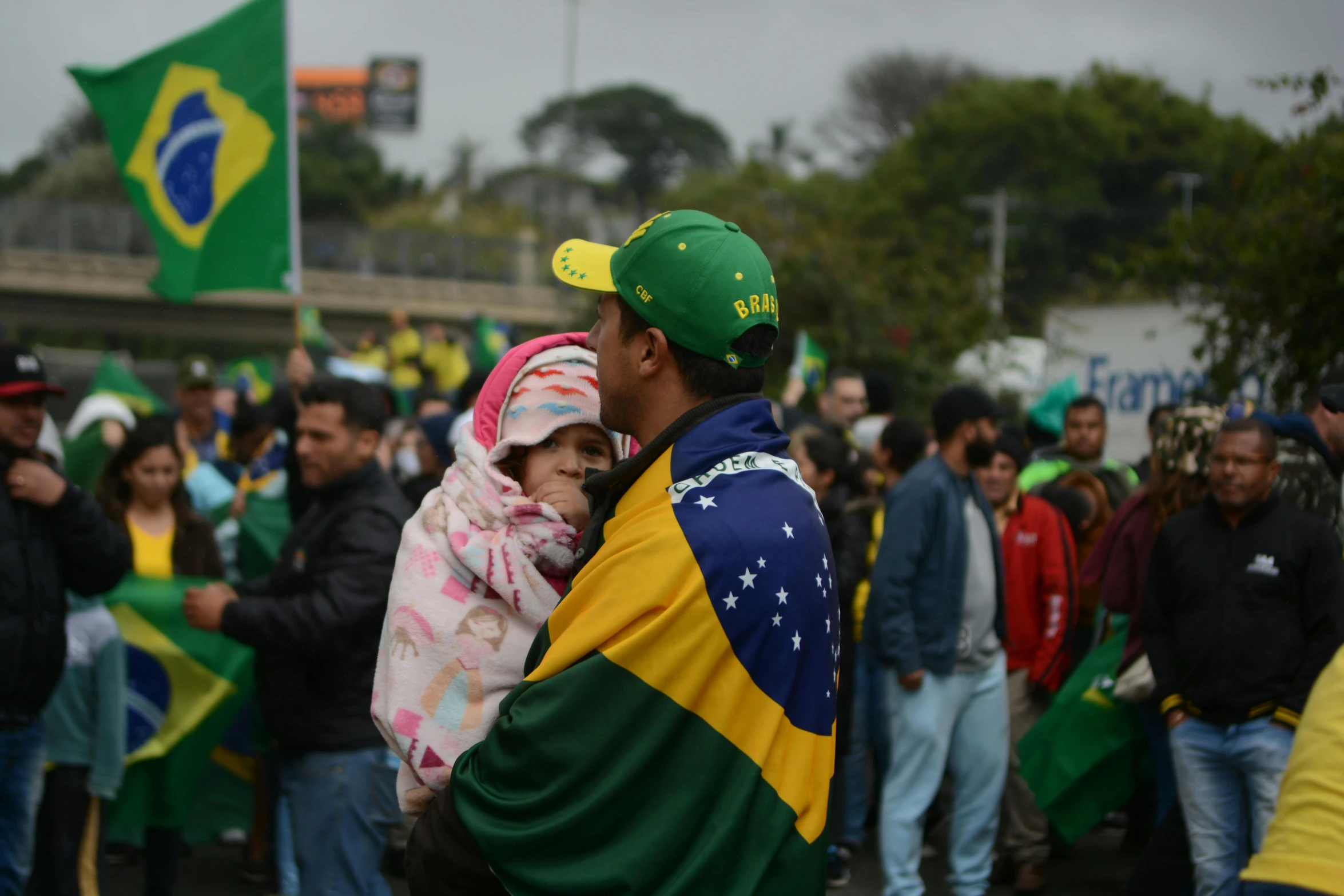 man and woman holding up zil's flag in front of a crowd