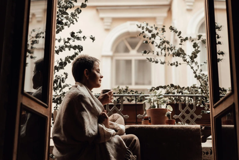 a person sitting on a couch and looking out of the window