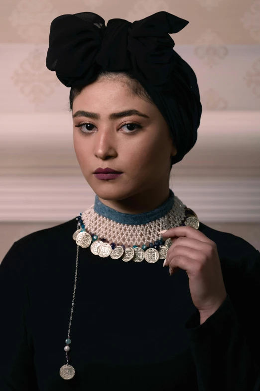 a woman in a turban wears a necklace