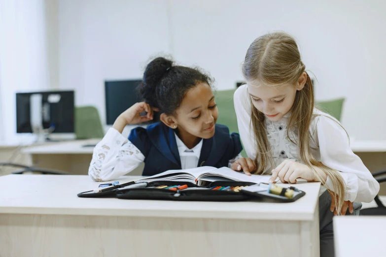 a girl and boy sit at a desk writing