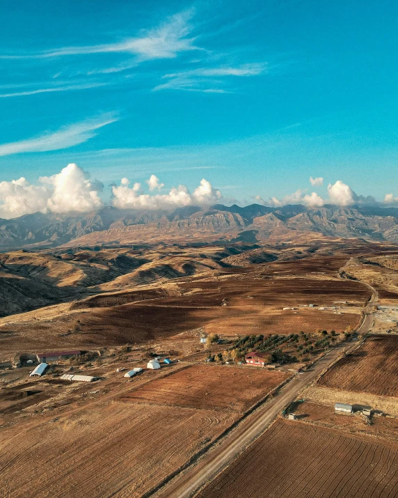 a large farm area with some fields and clouds