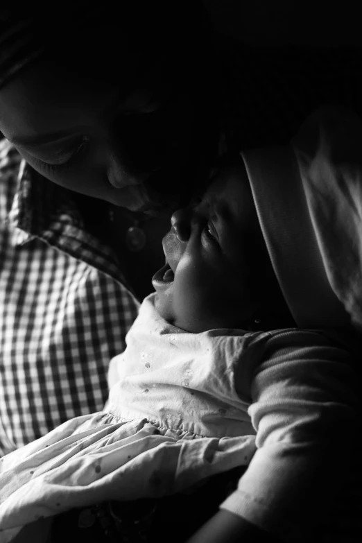 a man and woman holding their newborn son in the bed