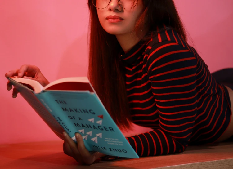 the young woman is sitting down reading a book