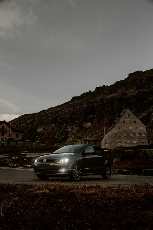 a dark car is driving near an abandoned mountaintop