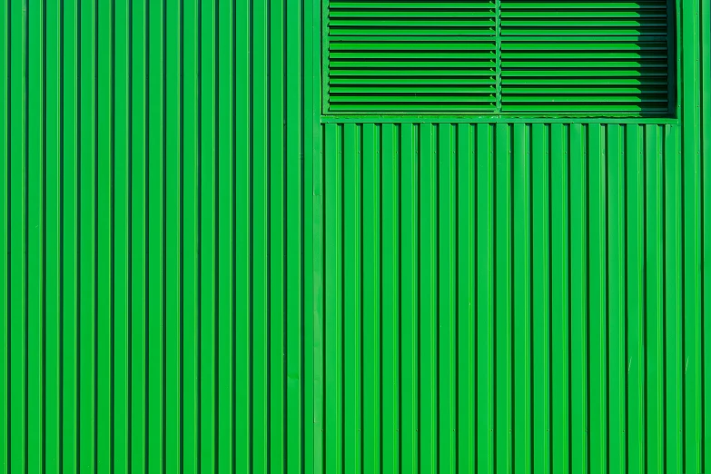 green metal wall with shutters and a door