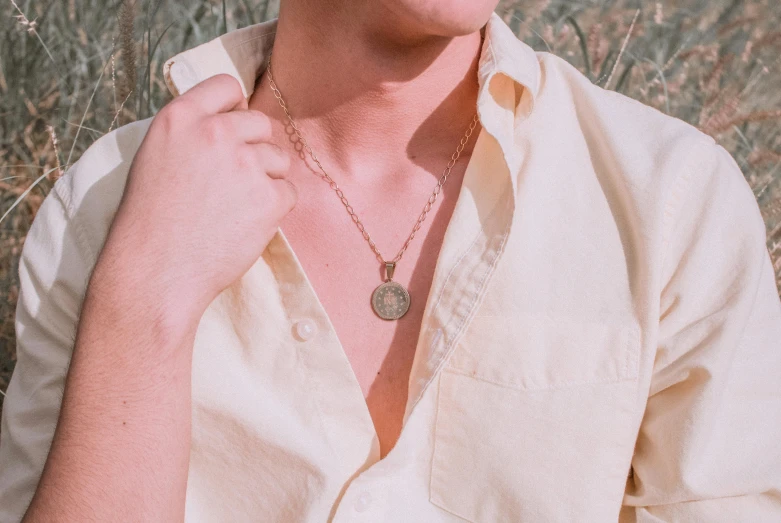 a woman wearing a white shirt and a black pendant