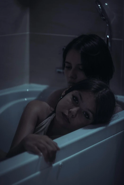 two women leaning against each other in the tub