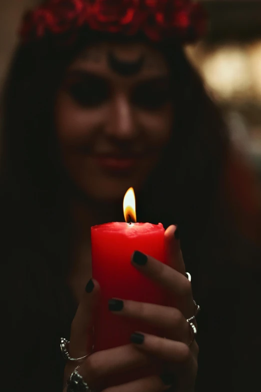 a woman holding a candle with her hands