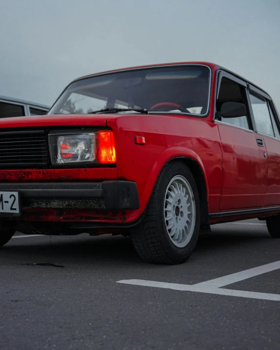 a small red car parked in a parking lot