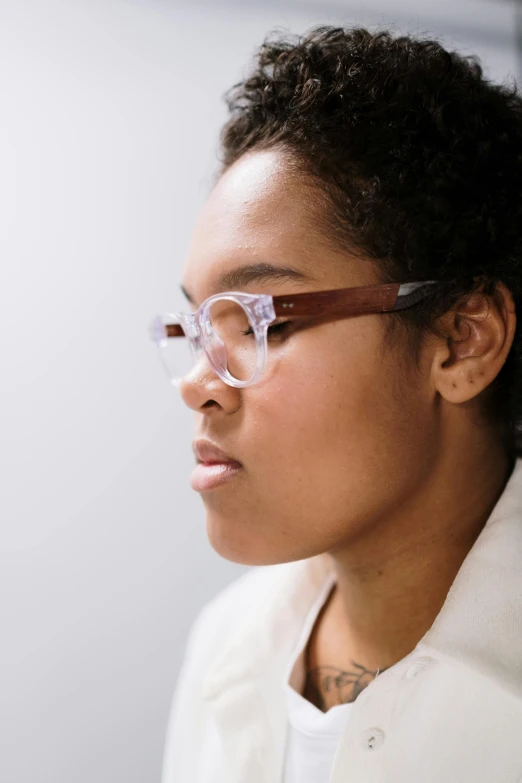 a woman wearing glasses and a white jacket