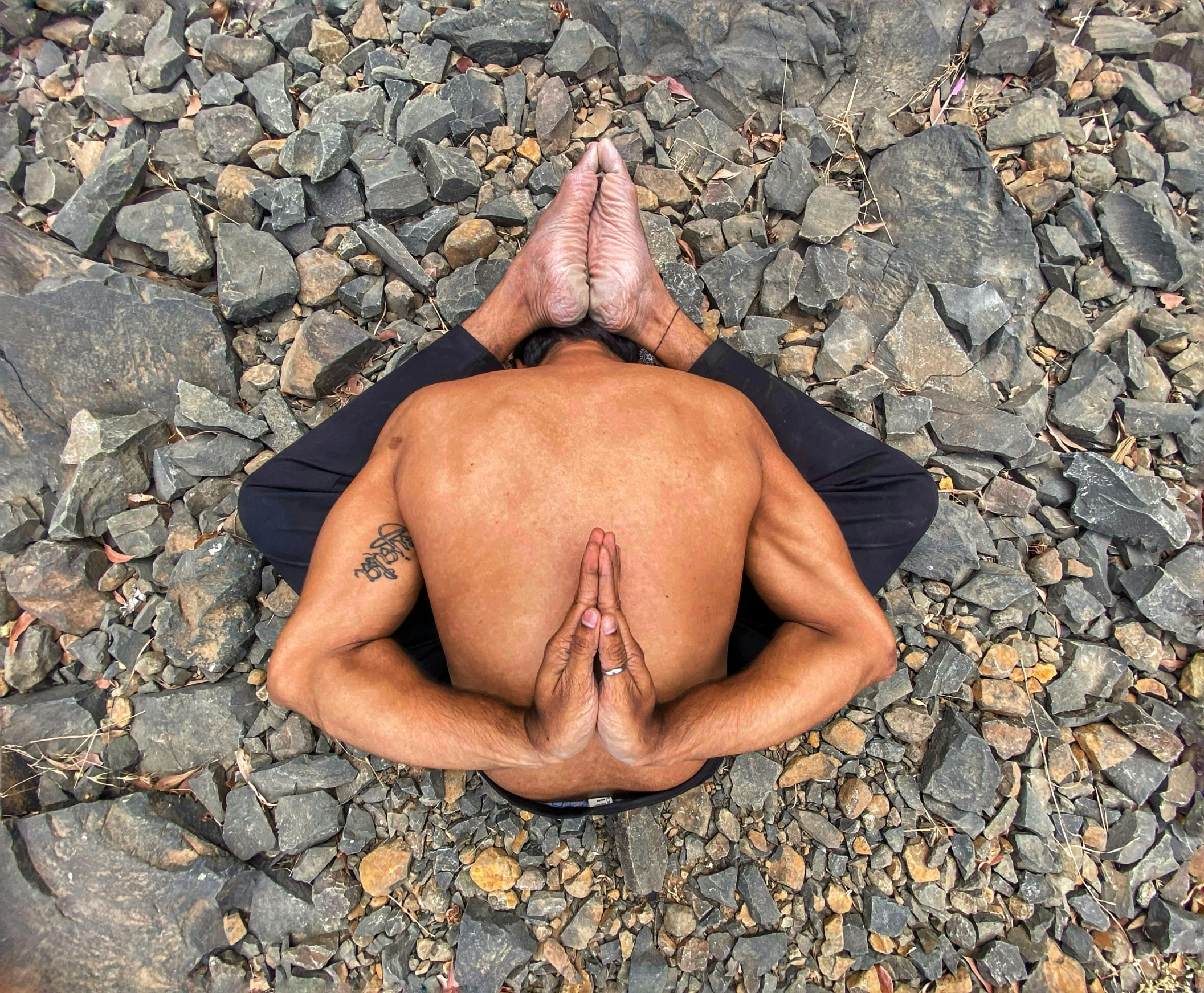 man laying on his back while meditating in the park