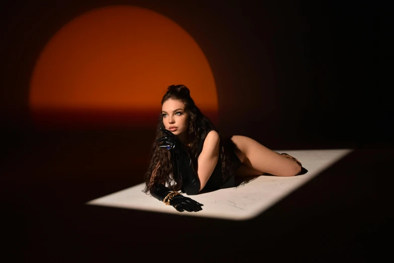 a girl in black dress sitting on white bed