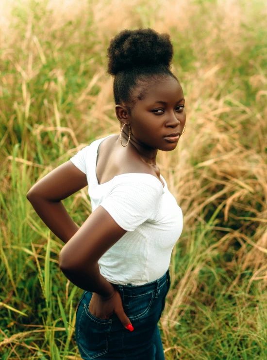 a woman stands in front of an overcast field