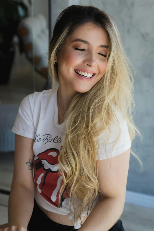 a smiling woman sitting down looking into the camera