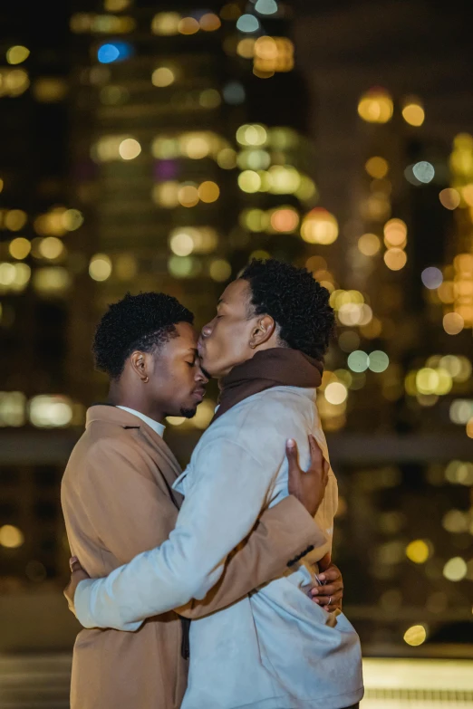 a man and woman hug each other as they stand in front of a large cityscape