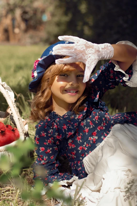 the girl sits in the field with her hat on