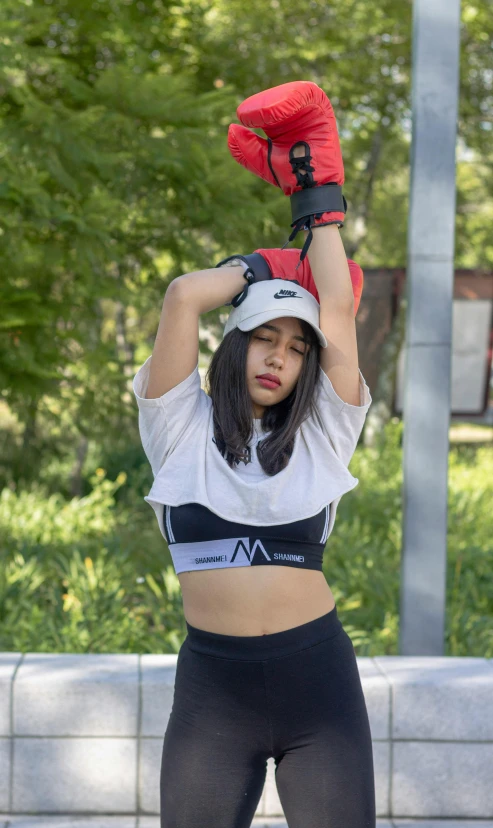 a woman in black leggings and crop top standing on top of a skateboard