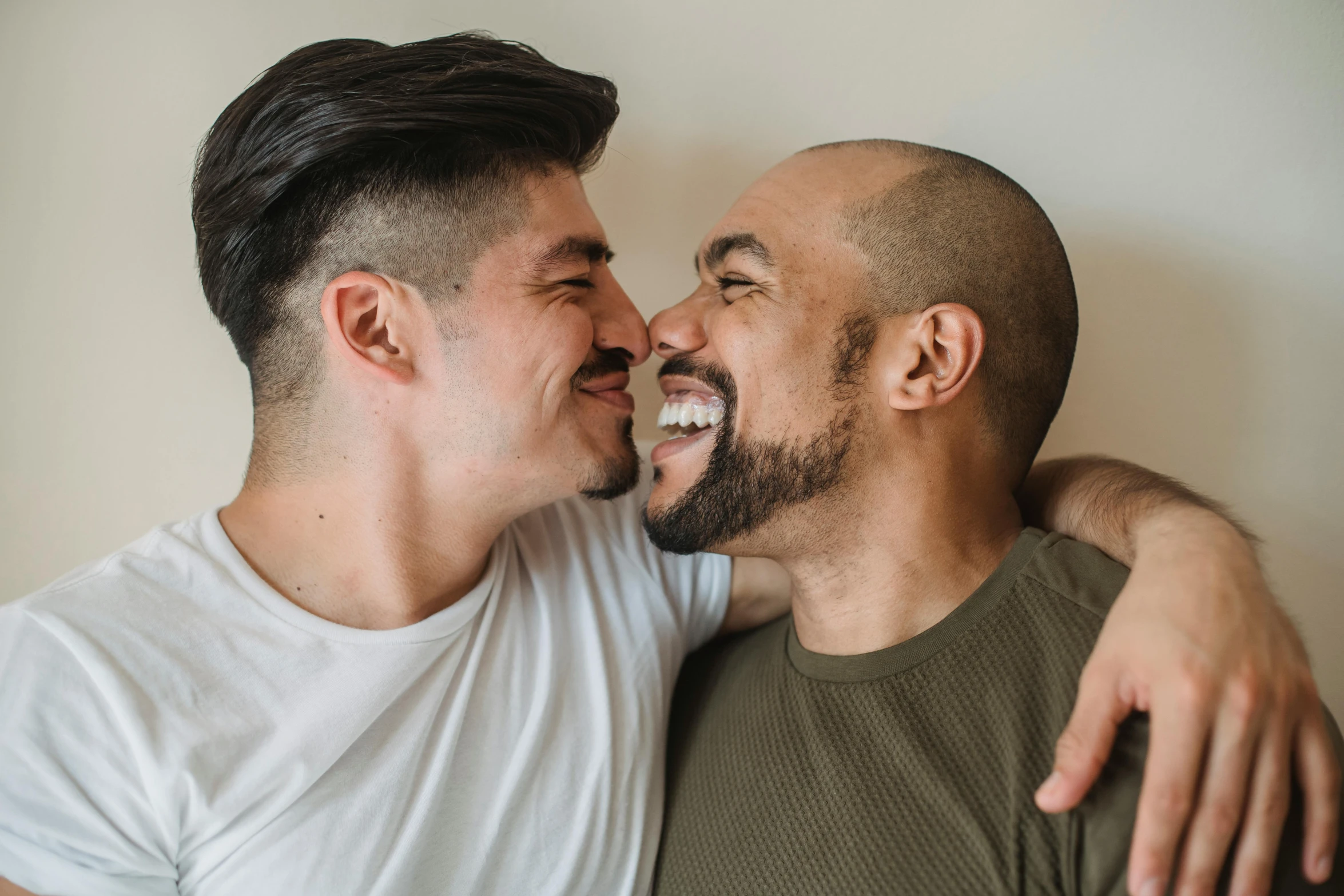 two men, one with black hair, are laughing together