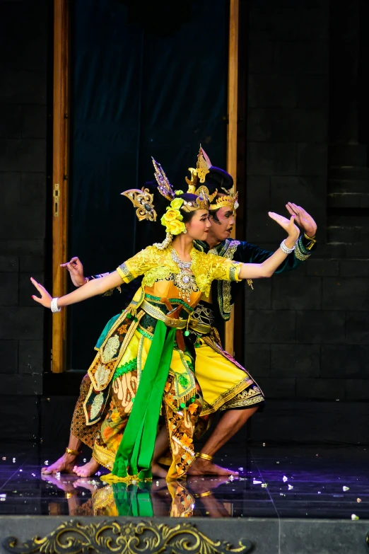 two women are dancing in different ethnic attire