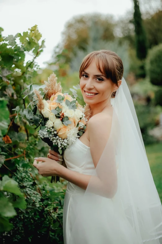 the bride is posing in the garden for a portrait