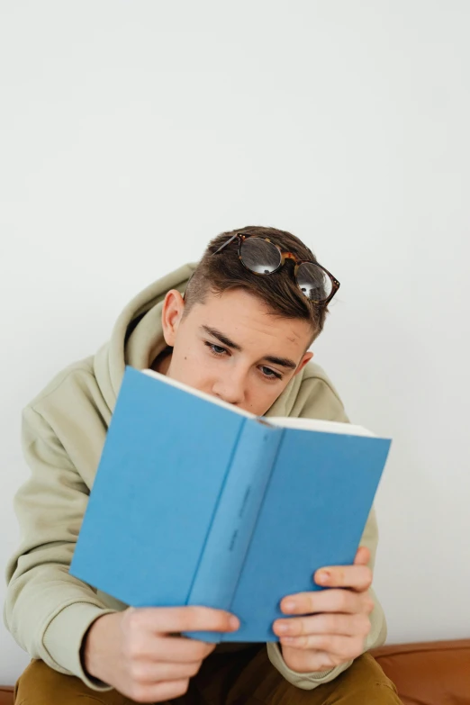 a man is sitting down reading a book