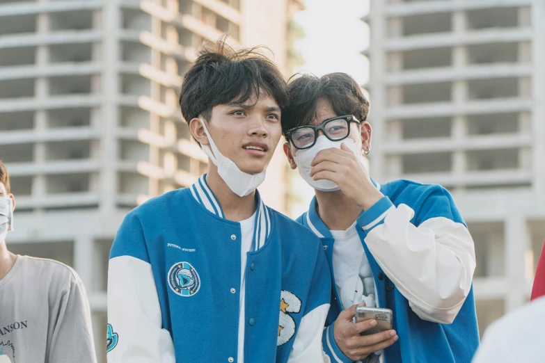 two boys wearing masks and sunglasses standing next to each other