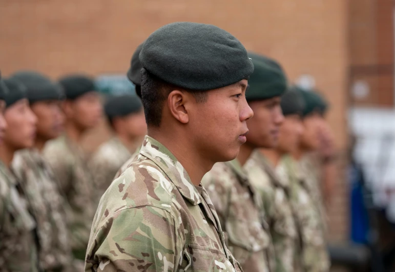 a row of uniformed men wearing green berets